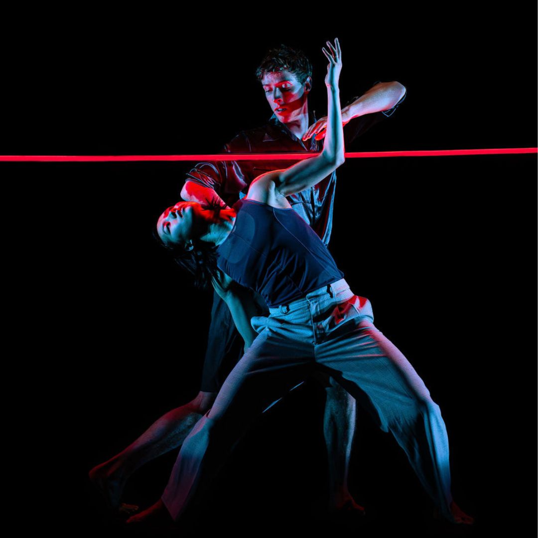 dancers under blue and red neon lights