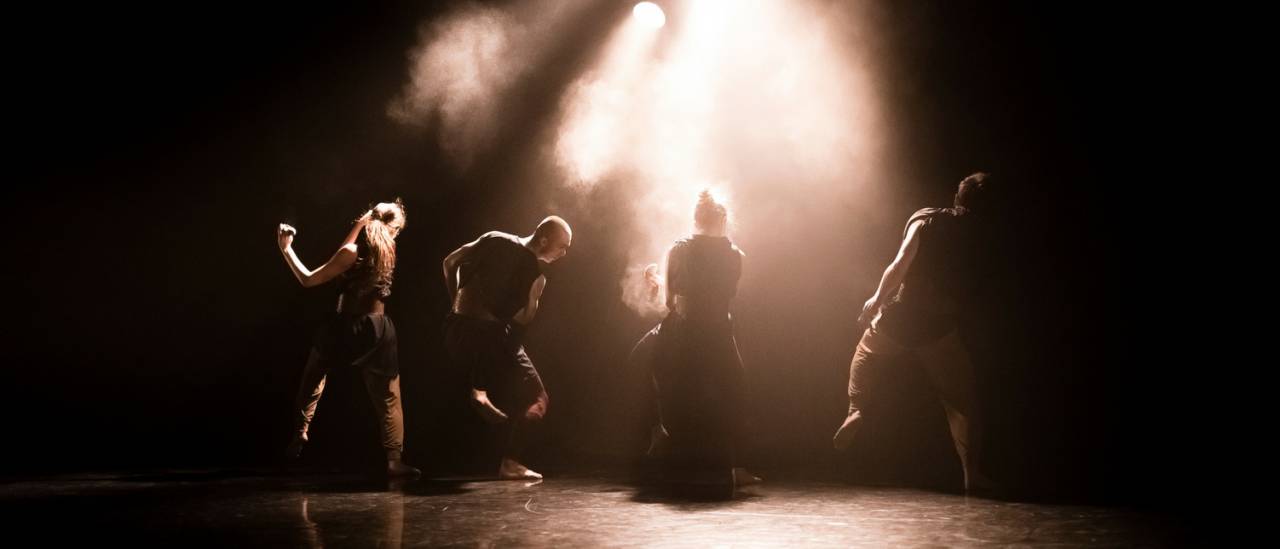 Atalay dancers facing the back with dust in the air