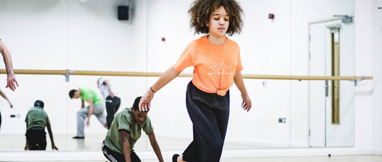 Community group, young dancer moving across the room