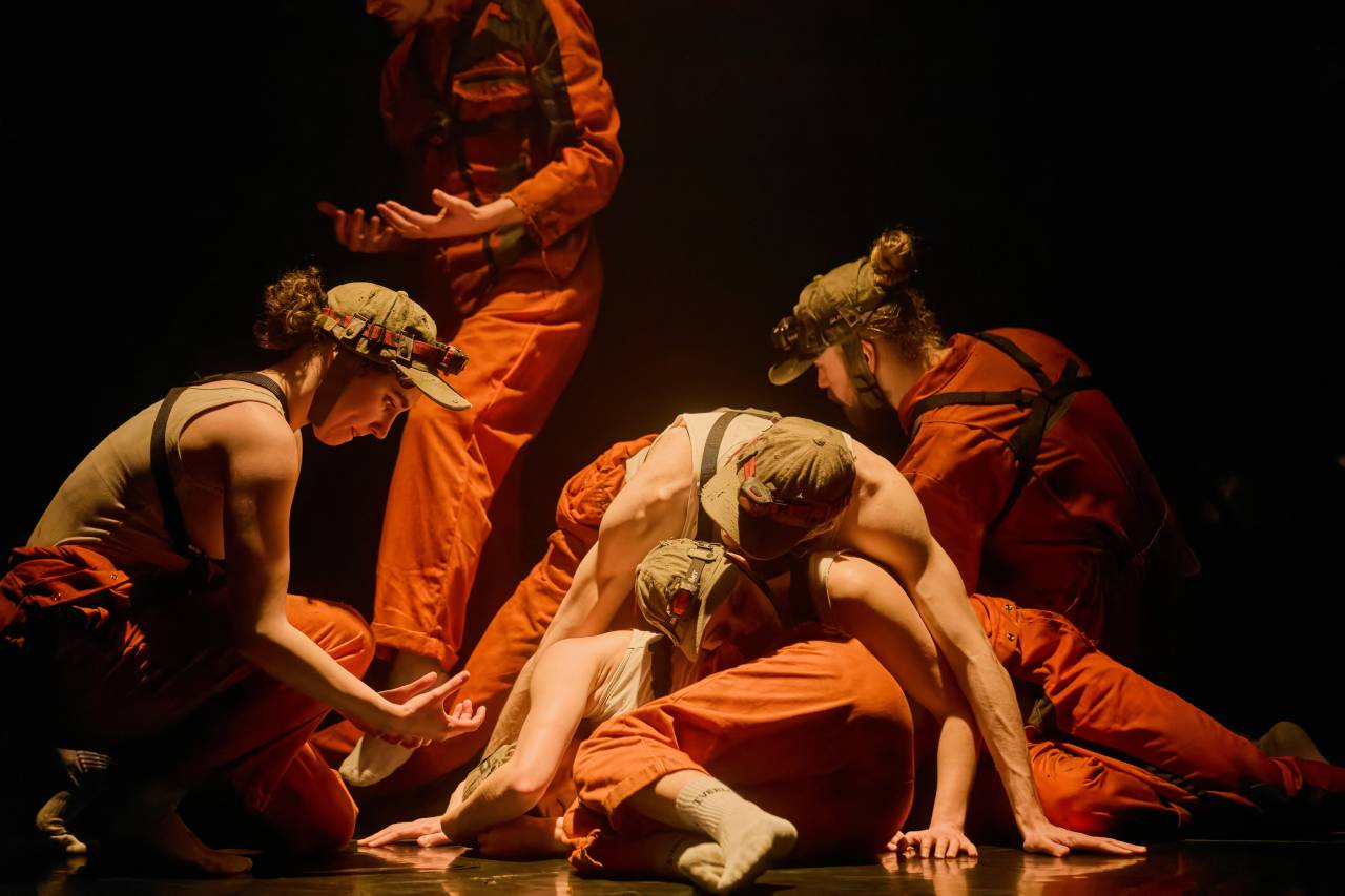 2 dancers 1 on the floor 1 looking down wearing a headlight