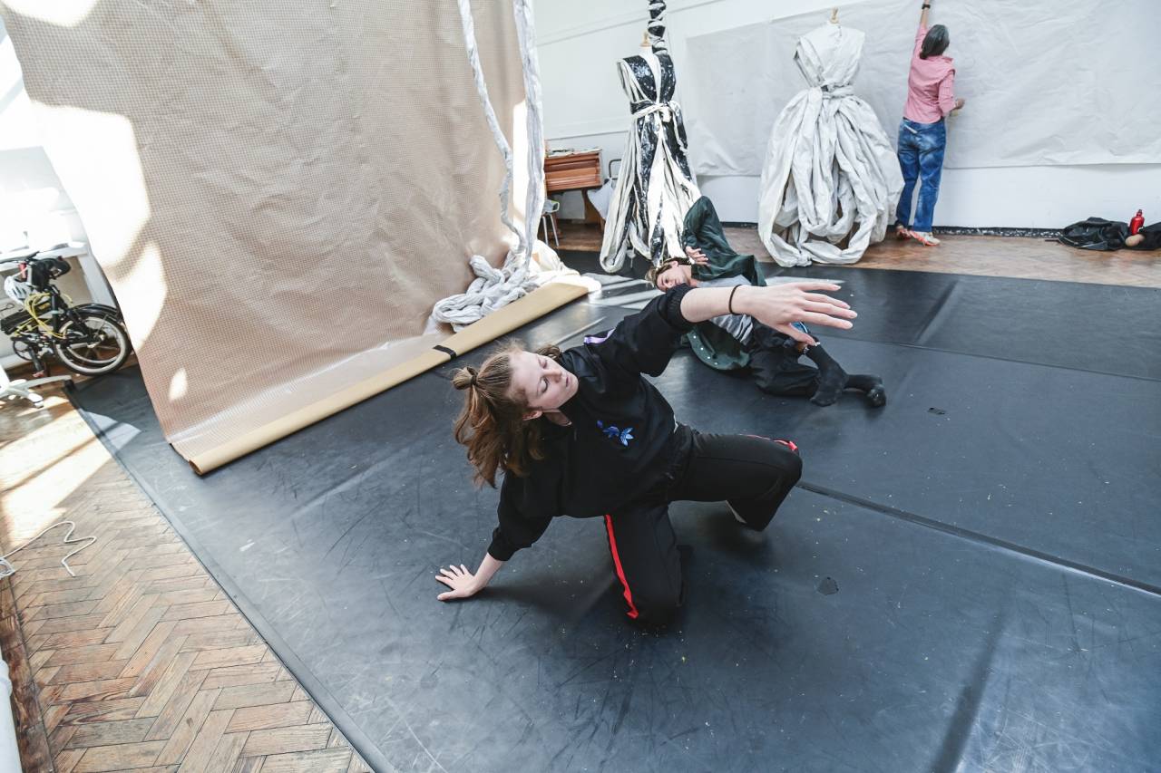 Dancer with plastic costumes in background