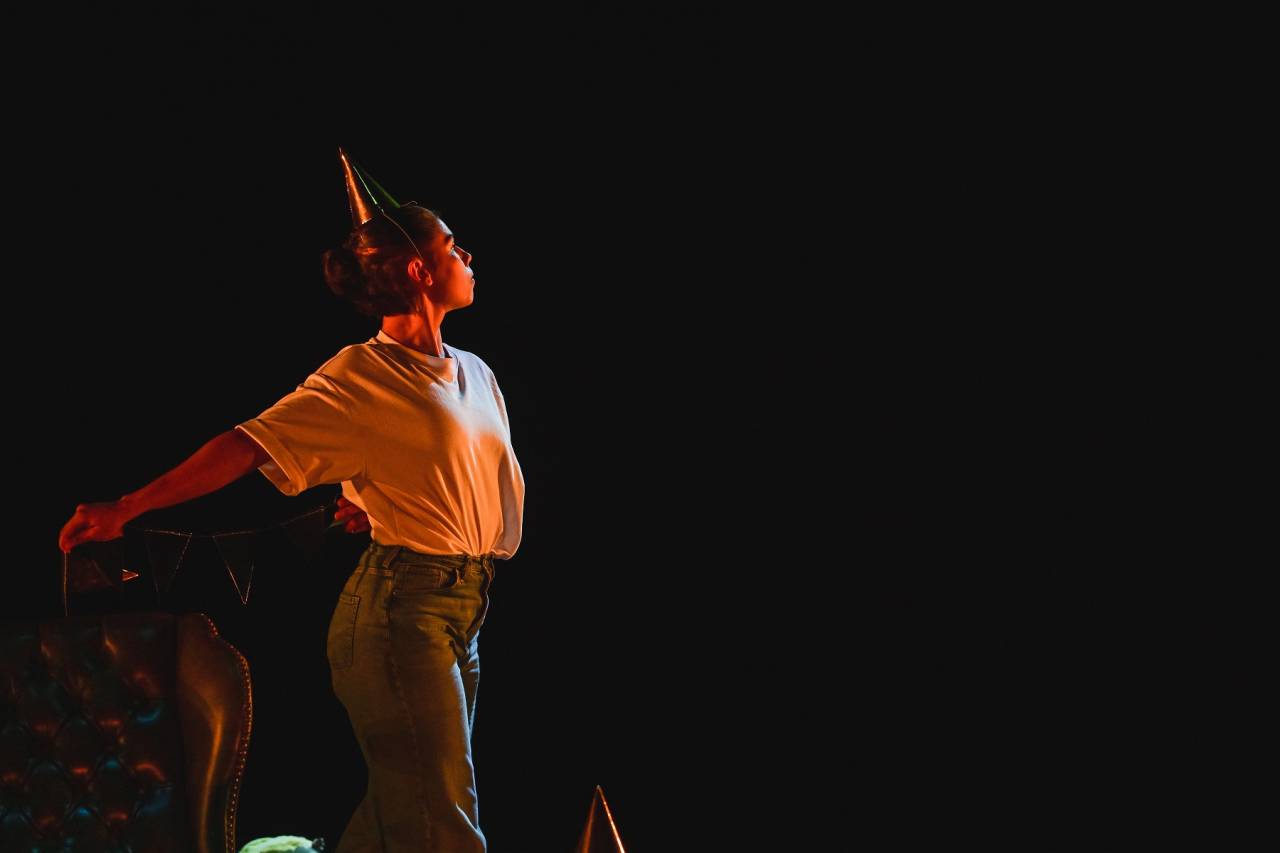 dancer in orange light and a gold party hat 