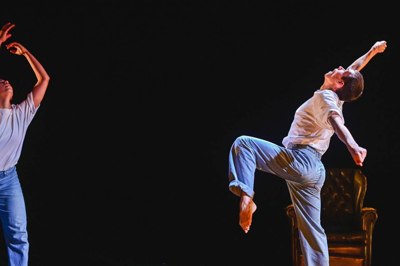 dancer in jeans and white shirt leaning backwards 