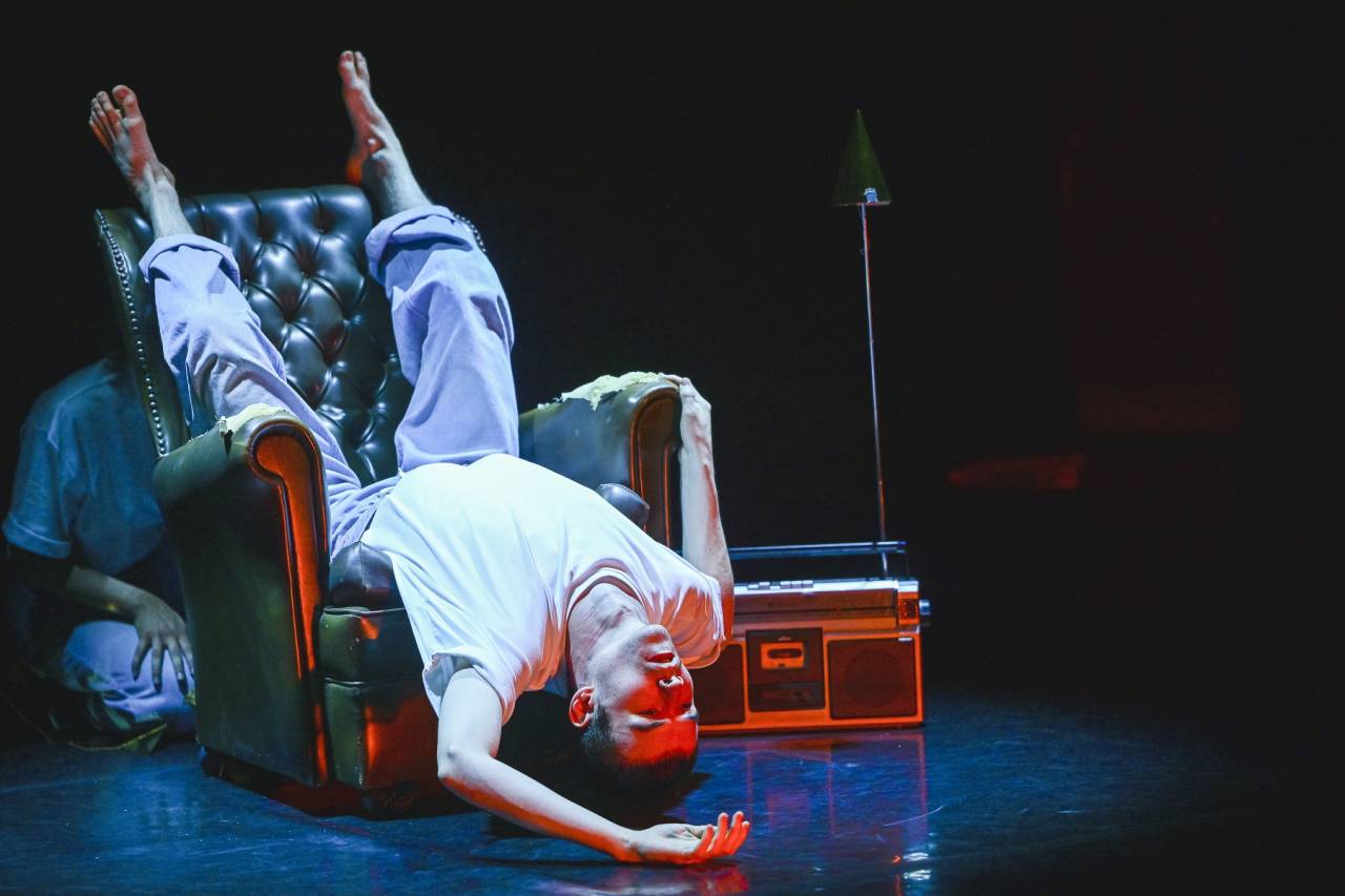 dancer lying upside down on old leather chair