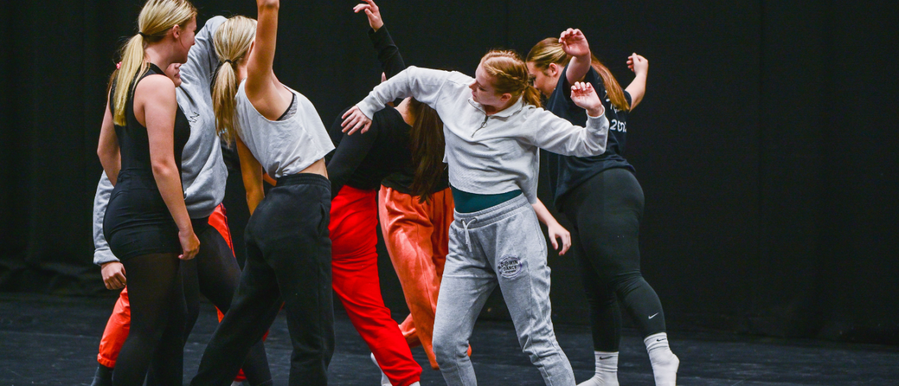 young people dancing in a black studio