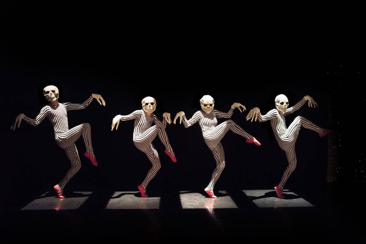 dancers in skeleton masks creeping across the stage.