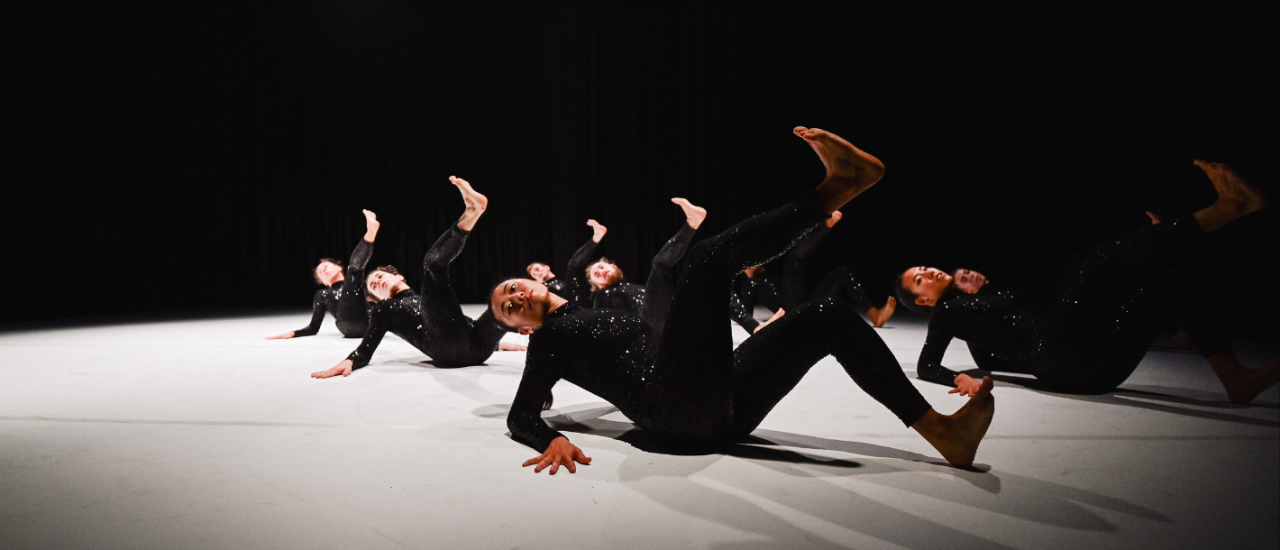 dancers in black sequin costumes moving together