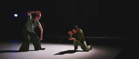 two dancers in soft light and green flowy outfits, looking as if they're casting spells